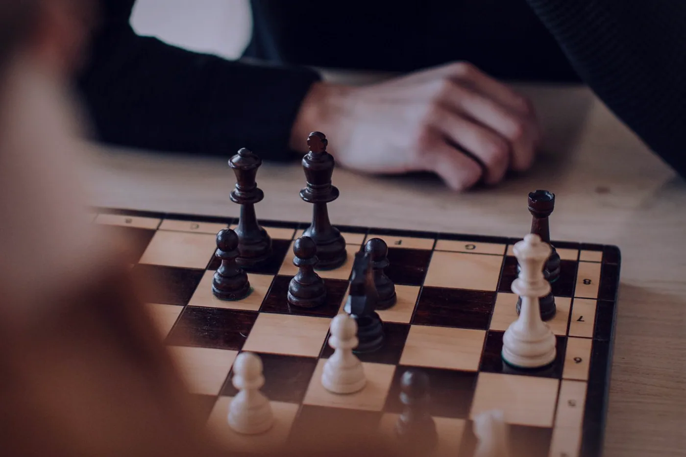 Two players leaning over a strategy board game